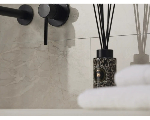 Moderne Wandfliesen in Marmoroptik mit schwarzer Armatur, Raumduft und weißen Handtüchern im Badezimmer.