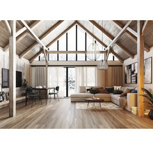 Großzügiges Wohnzimmer mit hohem Giebeldach, sichtbaren Holzbalken, grauem Ecksofa, Essbereich und hellem Holzboden im modernen Landhausstil.