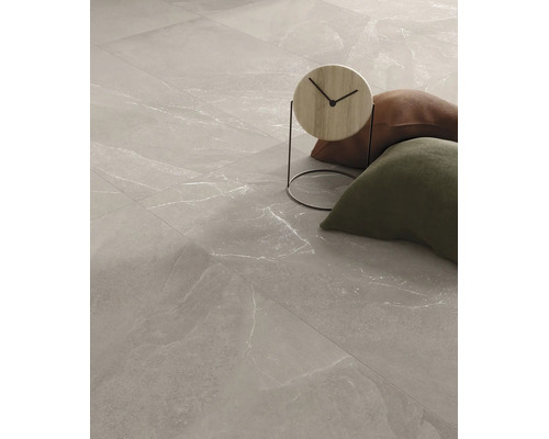 Großformatige Bodenfliesen aus Feinsteinzeug in grauer Marmoroptik mit hellen Maserungen in einem modern eingerichteten Raum.
