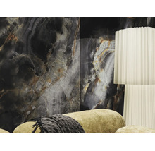 Großformatige Wandfliese in dunkler Onyx-Optik in einem modern gestalteten Wohnzimmer mit weißer Stehlampe und Sofa.