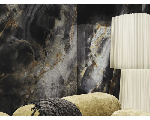 Großformatige Wandfliese in dunkler Onyx-Optik in einem modern gestalteten Wohnzimmer mit weißer Stehlampe und Sofa.