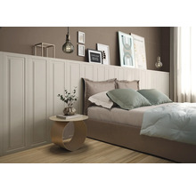 Modernes Schlafzimmer mit weißer Wandverkleidung in Kassettenoptik hinter einem Bett und dekorativen Bildern an der Wand.