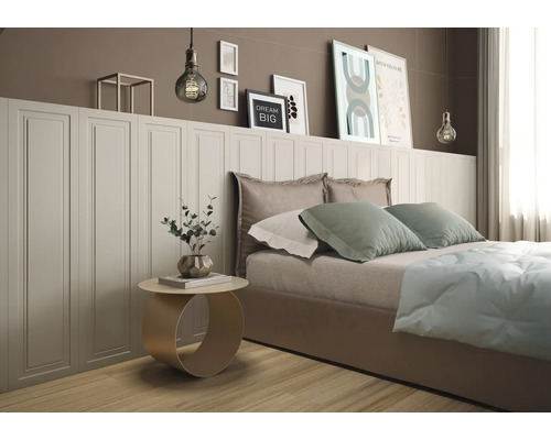 Modernes Schlafzimmer mit weißer Wandverkleidung in Kassettenoptik hinter einem Bett und dekorativen Bildern an der Wand.