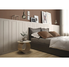 Modernes Schlafzimmer mit weißer Wandvertäfelung in Kassettenoptik, brauner Wand, Bett und rundem Beistelltisch auf hellem Holzboden.