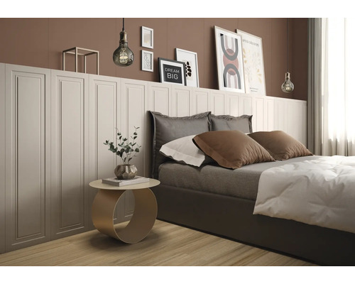 Modernes Schlafzimmer mit weißer Wandvertäfelung in Kassettenoptik, brauner Wand, Bett und rundem Beistelltisch auf hellem Holzboden.