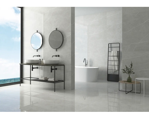 Modernes Badezimmer mit großformatigen Fliesen in Marmoroptik, Doppelwaschtisch mit zwei runden Spiegeln und freistehender Badewanne.