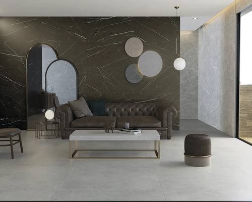Modernes Wohnzimmer mit Wandfliesen in dunkler Marmoroptik und hellgrauen Bodenfliesen aus Feinsteinzeug, Chesterfield-Sofa und Couchtisch.