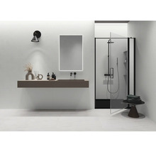 Modernes minimalistisches Badezimmer mit schwebendem Waschtisch, beleuchtetem Spiegel, schwarzer Armatur und Dusche mit schwarzem Rahmen.