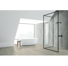 Modernes Badezimmer mit freistehender Badewanne, begehbarer Dusche mit schwarzem Rahmen und einem vertikalen Wandheizkörper vor einer grauen Wand.