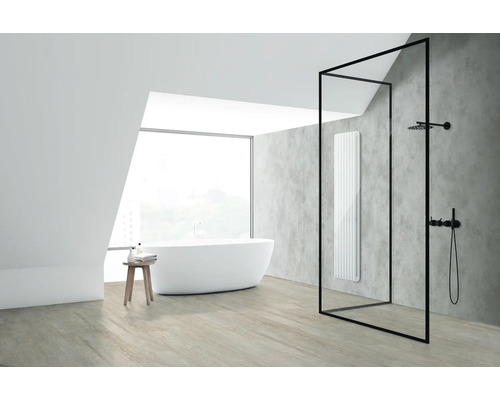 Modernes Badezimmer mit freistehender Badewanne, begehbarer Dusche mit schwarzem Rahmen und einem vertikalen Wandheizkörper vor einer grauen Wand.