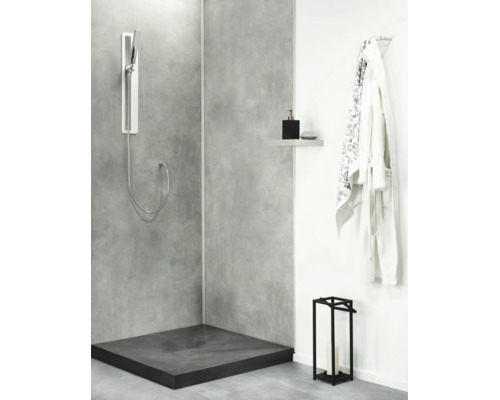 Moderne Duschecke mit Betonoptik Duschwand, bodengleicher Duschwanne, Handbrause und Ablageregal in einem zeitgenössischen Badezimmer.