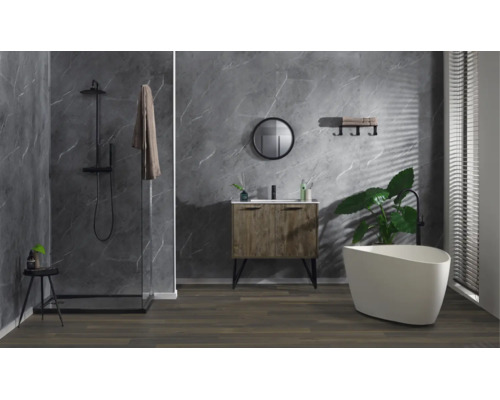 Modernes Badezimmer mit Dusche, Waschbeckenunterschrank in Holzoptik, rundem Spiegel und freistehender Badewanne vor marmorierter Wandverkleidung.