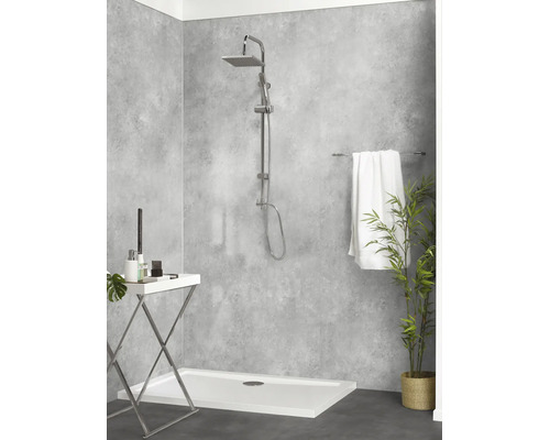 Moderne Dusche mit quadratischem Duschkopf, Wandverkleidung in Betonoptik, weißer Duschwanne, Handtuchhalter und dekorativer Pflanze.