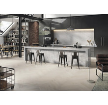 Moderne Küche im Loft-Stil mit Kochinsel in Betonoptik, Parkettboden in Fischgrätmuster, schwarzen Schränken und Backsteinwand.