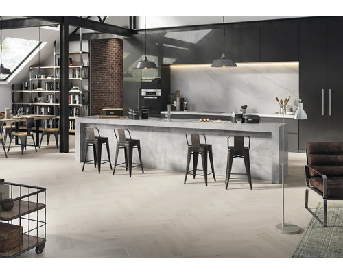 Moderne Küche im Loft-Stil mit Kochinsel in Betonoptik, Parkettboden in Fischgrätmuster, schwarzen Schränken und Backsteinwand.