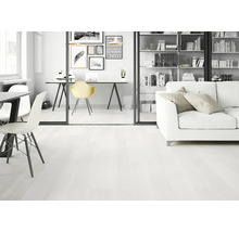 Hell gestalteter Wohnraum mit weißem Bodenbelag in Holzoptik, weißem Sofa, Glastüren und modernem Arbeitsbereich.