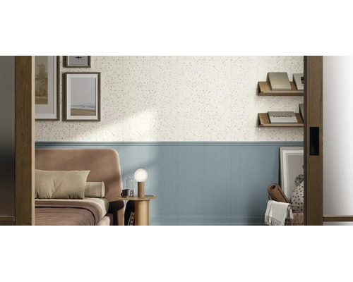 Wandgestaltung im Schlafzimmer mit weißen Fliesen in Terrazzo-Optik oben und hellblauen geriffelten Wandfliesen unten.