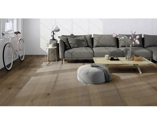 Modernes Wohnzimmer mit Parkettboden in Eichenoptik, grauem Sofa und hellem Holztisch in lichtdurchflutetem Ambiente.