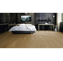 Modernes Schlafzimmer mit hellem Parkettboden, dunklen Wänden in Betonoptik, einem Doppelbett und einem Schreibtisch aus Holz.