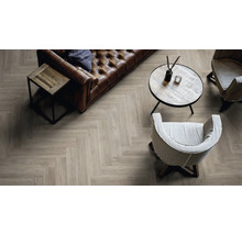 Wohnzimmer mit Fischgrät Laminatboden in Holzoptik, Ledersofa und Sesseln in einem gemütlichen und stilvollen Einrichtungsstil.