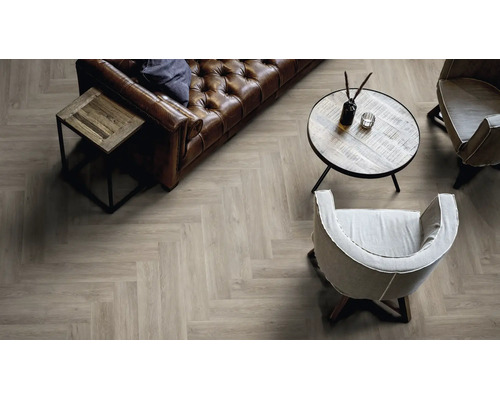 Wohnzimmer mit Fischgrät Laminatboden in Holzoptik, Ledersofa und Sesseln in einem gemütlichen und stilvollen Einrichtungsstil.