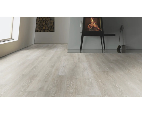 Heller Laminatboden in Holzoptik in einem Wohnraum mit Kaminofen und Kaminbesteck.