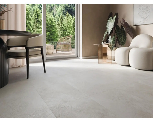 Heller Fliesenboden in einem modernen Wohnzimmer mit Zugang zur Terrasse und Blick in den Wald.