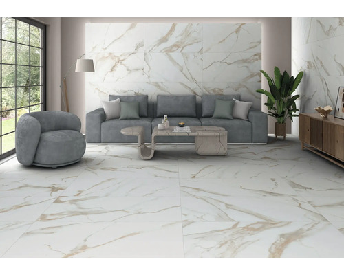 Modernes Wohnzimmer mit großformatigen Boden- und Wandfliesen in Marmoroptik mit goldener Maserung, grauem Sofa und heller Atmosphäre.