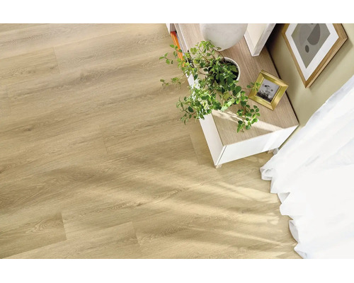 Heller Laminatboden in Holzoptik verlegt in einem hellen Wohnraum mit Pflanze und Sideboard.