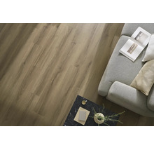 Wohnraum mit verlegtem Laminatboden in Holzoptik, dazu ein graues Sofa und ein Beistelltisch in Marmoroptik.