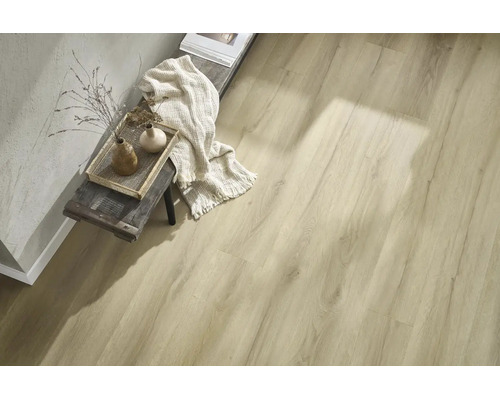 Laminatboden in Holzoptik verlegt in einem Wohnraum mit Holzhocker, Textildekoration und strukturierter Wand