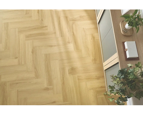 Laminatboden in Fischgrätoptik in Eichenholzoptik verlegt in einem hellen Wohnraum mit Holzmöbeln und Dekoration.