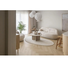 Helles, modern eingerichtetes Wohnzimmer mit Sofa, Couchtisch und Fischgrätparkett.