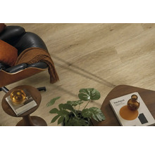 Wohnraum mit Laminatboden in Holzoptik, dazu ein Sessel aus Leder und Holztischen mit Dekoration in einem modern eingerichteten Zimmer.