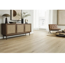 Heller Holzoptik Bodenbelag in einem modern eingerichteten Wohnzimmer mit Rattan Kommode und Ledersessel in wohnlicher Atmosphäre.