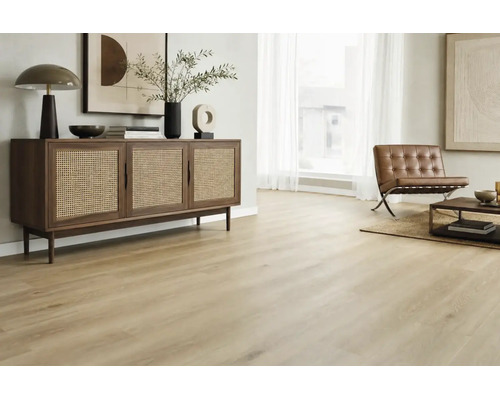 Heller Holzoptik Bodenbelag in einem modern eingerichteten Wohnzimmer mit Rattan Kommode und Ledersessel in wohnlicher Atmosphäre.