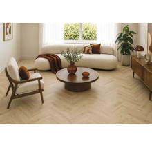 Modernes Wohnzimmer mit hellem Fischgrätparkett Bodenbelag, kurvigem Sofa, Sessel, rundem Couchtisch und dekorativen Accessoires.