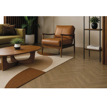 Wohnzimmer mit Fischgrätparkett, Ledersessel, Holztisch und Dekoration in modernem, wohnlichem Design