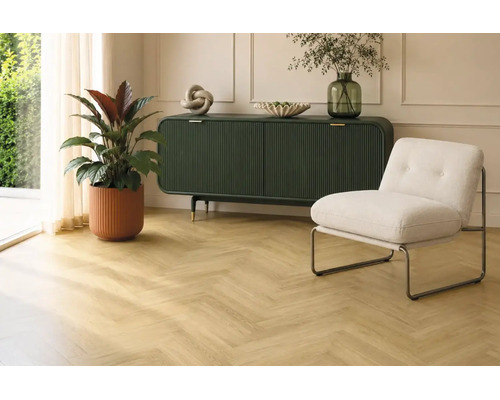Wohnraum mit Eichenholzparkett im Fischgrätmuster, dunkelgrünem Sideboard, modernem Sessel und Zimmerpflanze in hellem Raum.