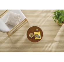 Draufsicht auf einen hellen Holzboden in einem modern eingerichteten Raum mit Sessel, rundem Holztisch, Zimmerpflanze und Dekoration.
