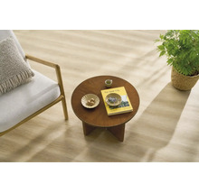 Heller Holzoptik Laminatboden in einem wohnlich eingerichteten Raum mit Sessel und kleinem Holztisch.