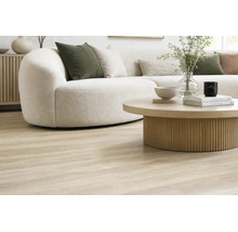 Wohnzimmer mit hellem Laminatboden in Holzoptik, kurvigem Sofa und rundem Couchtisch aus Holz für eine wohnliche und moderne Atmosphäre.