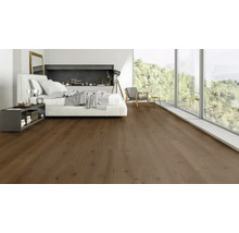 Modernes Schlafzimmer mit braunem Holzboden, großes Fenster mit Blick ins Grüne, minimalistische Einrichtung und weiße Wandgestaltung.