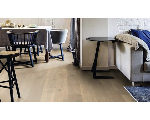 Heller Parkettboden in einem modern eingerichteten Wohnzimmer mit Essbereich und Sofa.