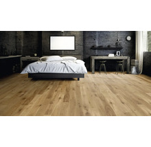 Modernes Schlafzimmer mit rustikalem Eichenparkett Bodenbelag und dunkler Betonwandoptik in einem geräumigen und wohnlichen Ambiente.