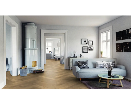 Helles Wohnzimmer mit Parkettboden im Fischgrätmuster, Kachelofen, Sofa und Couchtisch in einer modernen und freundlichen Atmosphäre.