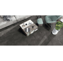 Modernes Wohnzimmer mit dunklen Bodenfliesen in Betonoptik, Couchtisch aus Holz und Marmor sowie Sitzgelegenheiten in einem offenen Wohnbereich.