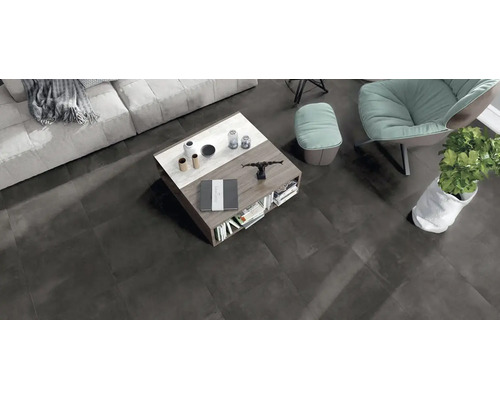 Modernes Wohnzimmer mit dunklen Bodenfliesen in Betonoptik, Couchtisch aus Holz und Marmor sowie Sitzgelegenheiten in einem offenen Wohnbereich.