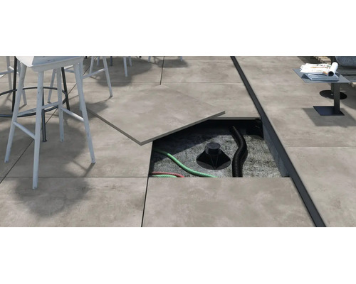Terrassengestaltung mit Stelzlager System fuer Keramikplatten auf einer Terrasse mit sichtbarer Unterkonstruktion und verlegten Rohren