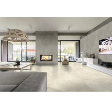 Modernes Wohnzimmer mit hellen Fliesenboden, Kamin in einer Wand aus Sichtbeton Optik, offener Wohnbereich mit grosser Fensterfront.